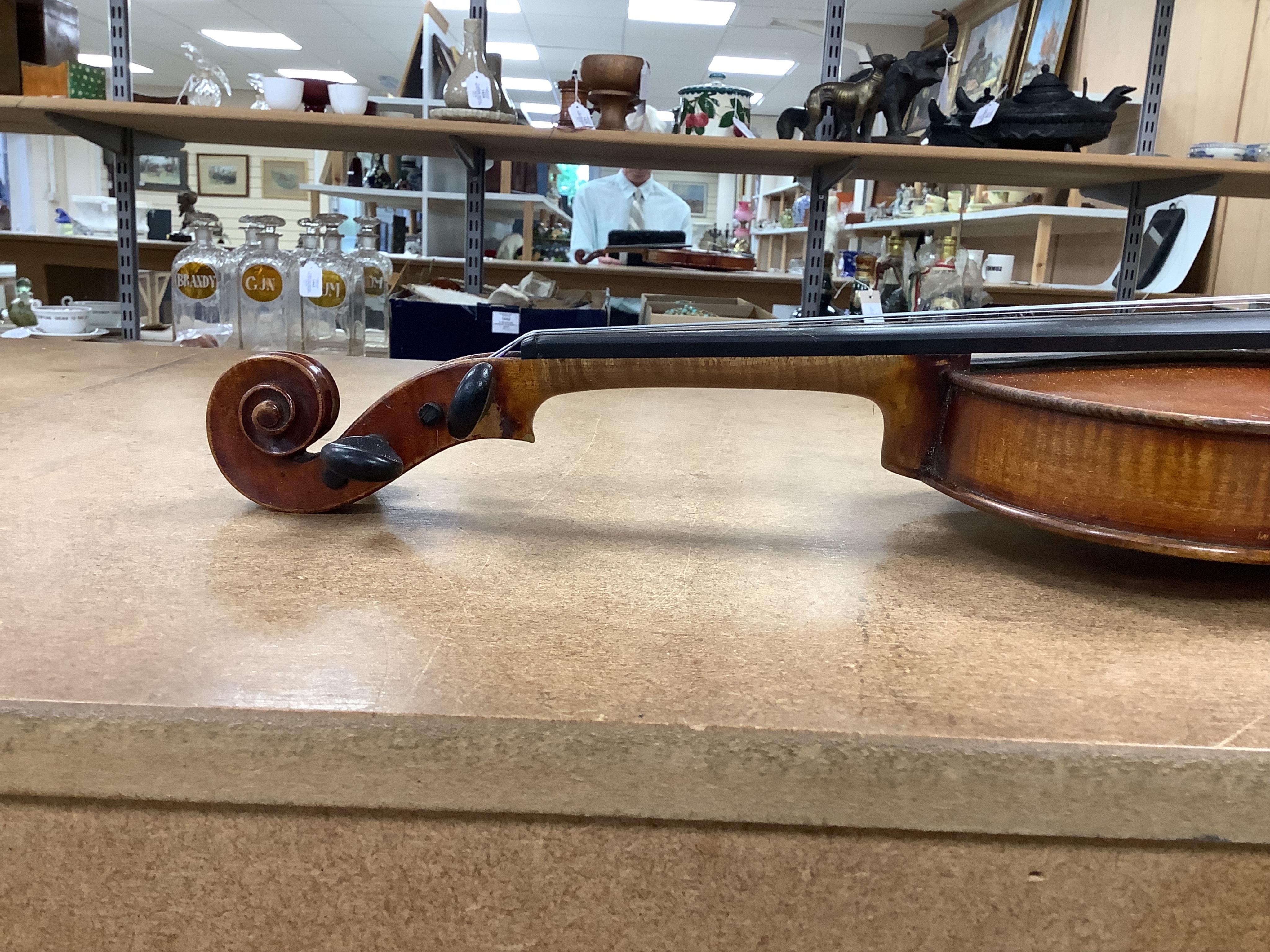 An early 20th century cased violin and cover, 60cm long